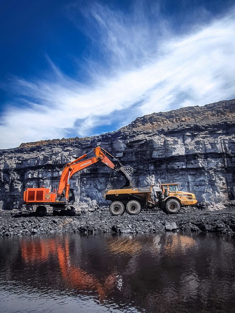 Excavator and haul truck working an open-cut mine pit